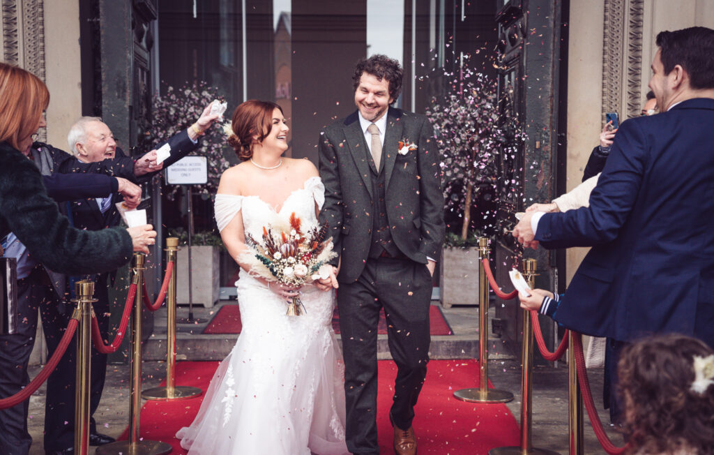 bride and groom walking in confetti in liverpool st george's hall